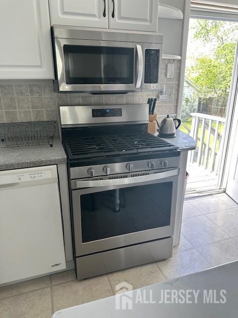 68 Suydam Ave, Edison, NJ 08817 - kitchen with appliances with stainless steel finishes, white cabinetry, tasteful backsplash, and light tile patterned floors