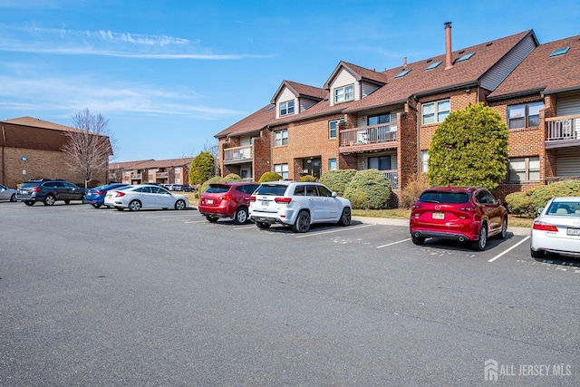 view of building exterior with a residential view and uncovered parking