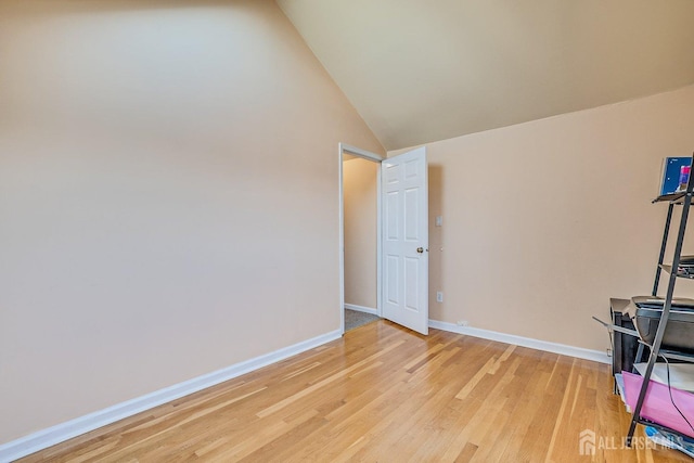 interior space with light wood-style floors, baseboards, and high vaulted ceiling