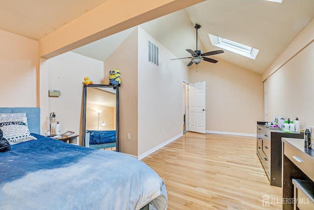 bedroom with visible vents, high vaulted ceiling, light wood-style floors, a skylight, and baseboards