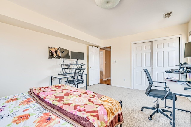 carpeted bedroom with a closet, visible vents, and baseboards