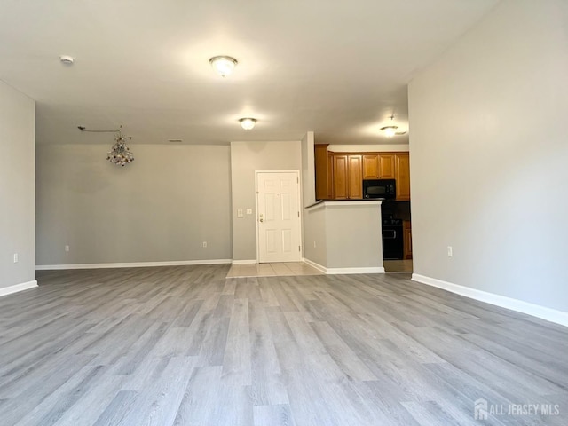 unfurnished living room with baseboards and light wood finished floors