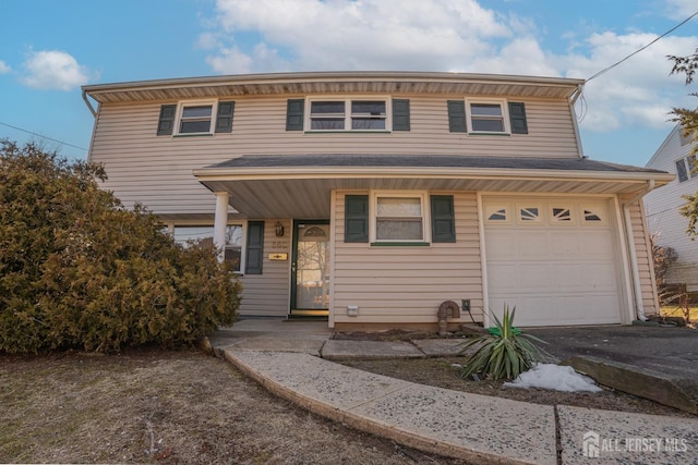 view of front of home with aphalt driveway and a garage