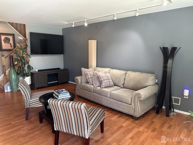 8 Bristol Dr, North Brunswick, NJ 08902 - living room with rail lighting, light wood-style flooring, and baseboards