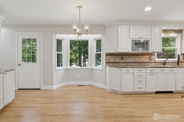 3 Cedar Ln, Milltown, NJ 08850 - kitchen featuring stainless steel microwave, plenty of natural light, white cabinetry, light wood-style floors, and recessed lighting