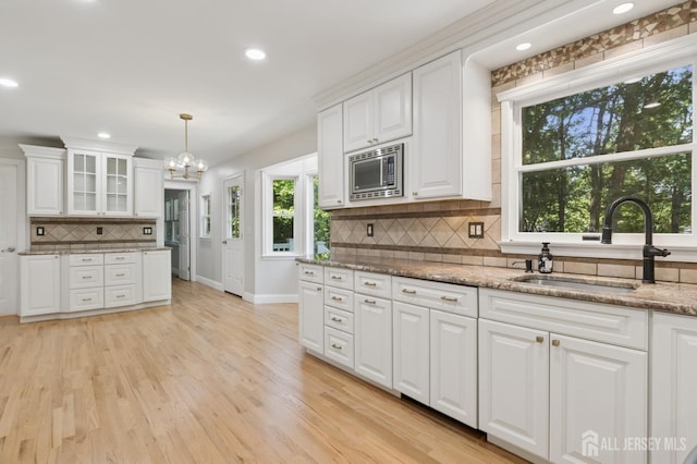 3 Cedar Ln, Milltown, NJ 08850 - kitchen featuring stainless steel microwave, backsplash, white cabinets, a chandelier, and recessed lighting