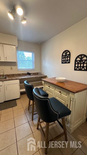 46 Gramercy Gdns, Middlesex, NJ 08846 - kitchen with light tile patterned floors, white cabinets, wood counters, and a sink