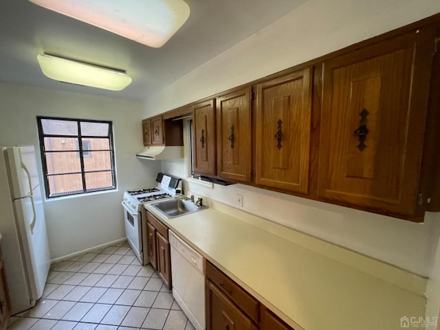 kitchen featuring light countertops, light tile patterned flooring, a sink, white appliances, and under cabinet range hood