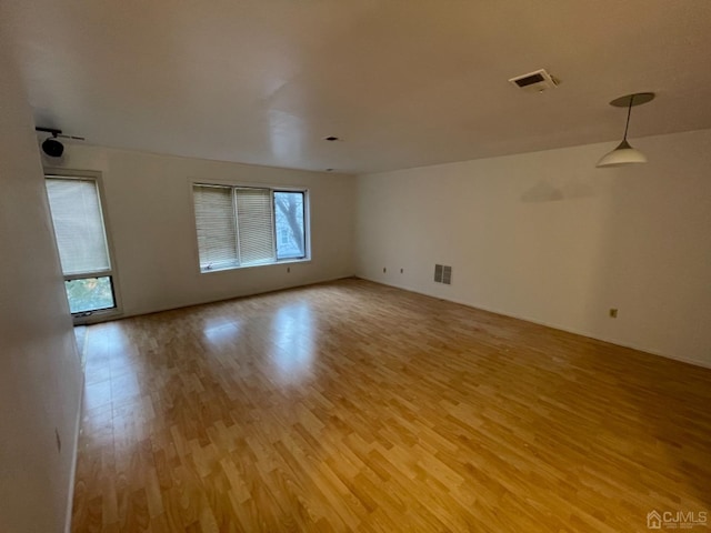 unfurnished room featuring light wood-style flooring and visible vents