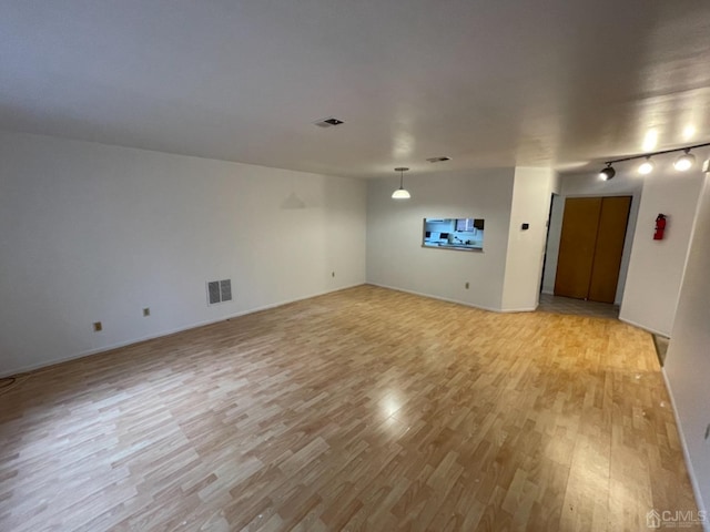 unfurnished room with light wood finished floors and visible vents