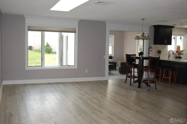 dining area featuring hardwood / wood-style flooring, ornamental molding, and sink