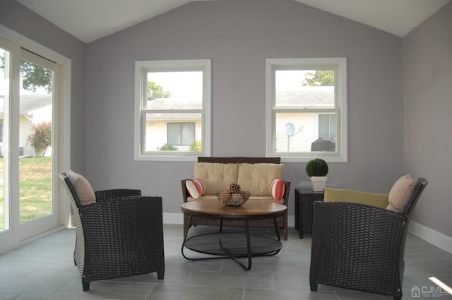 sitting room with vaulted ceiling, baseboards, and tile patterned floors