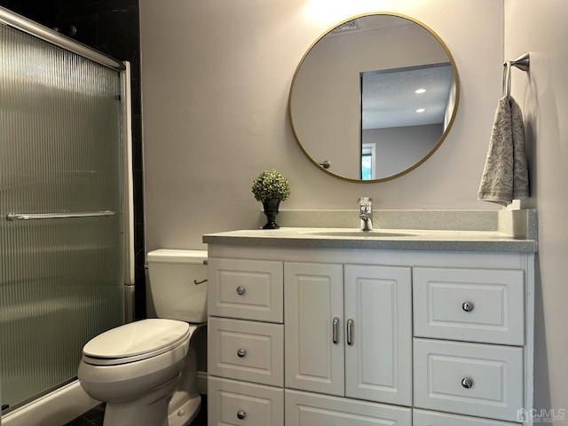 bathroom featuring toilet, a shower stall, and vanity