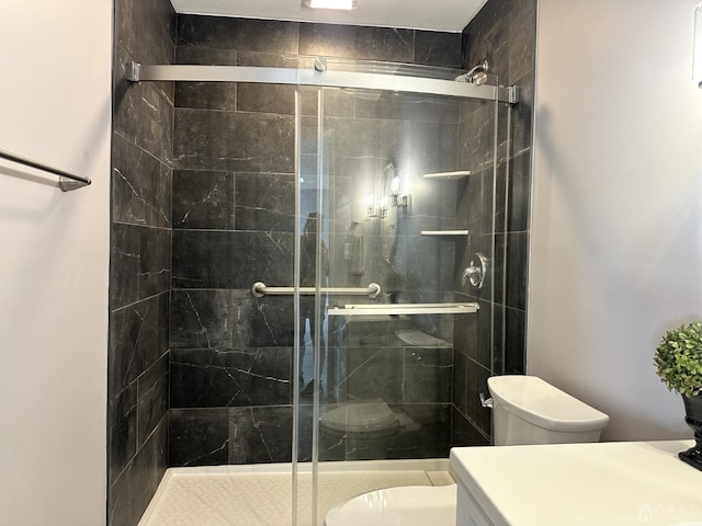 bathroom with vanity, a shower stall, and toilet