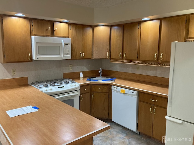 134 Hatfield Ln, East Brunswick, NJ 08816 - kitchen featuring white appliances, a sink, light countertops, and brown cabinetry