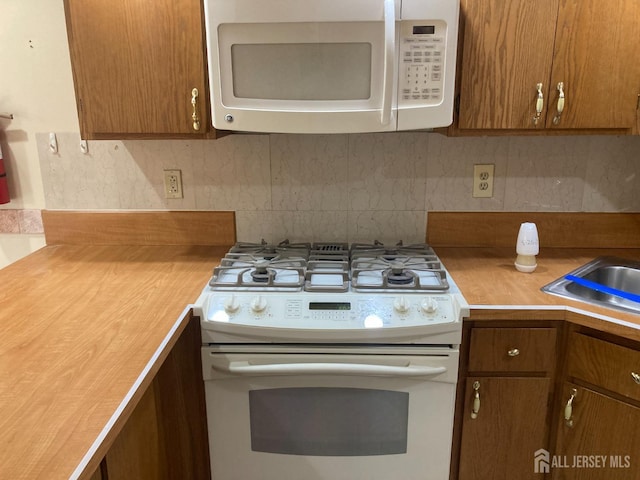 134 Hatfield Ln, East Brunswick, NJ 08816 - kitchen with white appliances, light countertops, decorative backsplash, and brown cabinetry