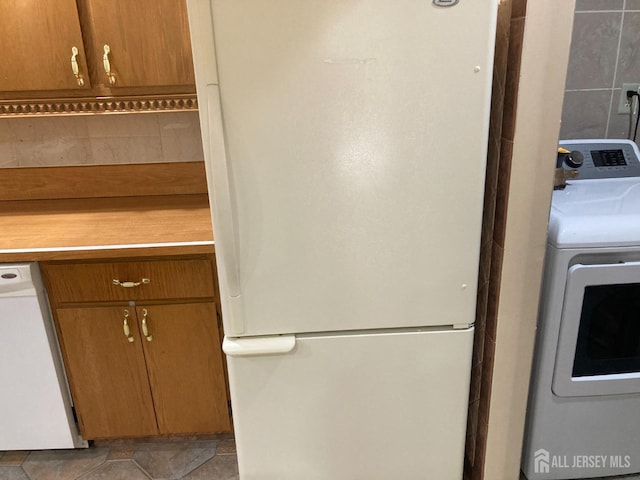 134 Hatfield Ln, East Brunswick, NJ 08816 - kitchen with white appliances, washer / dryer, light countertops, and brown cabinetry