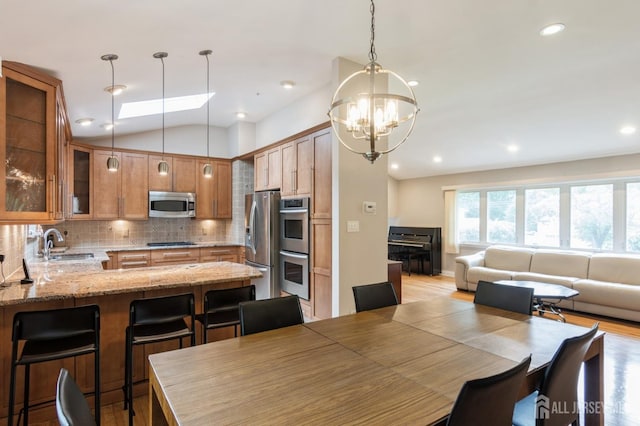 14 Agate Rd, East Brunswick, NJ 08816 - dining area featuring vaulted ceiling, a chandelier, light wood finished floors, recessed lighting, and a skylight