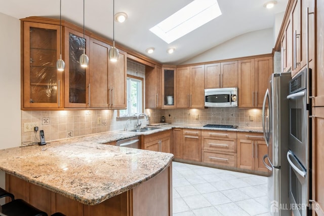 14 Agate Rd, East Brunswick, NJ 08816 - kitchen with stainless steel appliances, a sink, a peninsula, vaulted ceiling, and light stone countertops