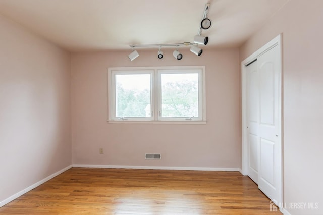 14 Agate Rd, East Brunswick, NJ 08816 - unfurnished dining area featuring light wood-style floors, rail lighting, and baseboards