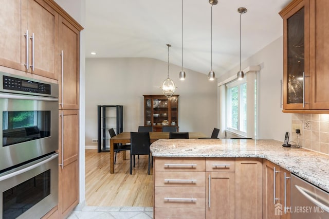 14 Agate Rd, East Brunswick, NJ 08816 - kitchen featuring appliances with stainless steel finishes, lofted ceiling, light stone countertops, a peninsula, and brown cabinets