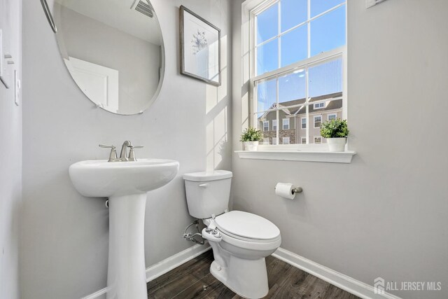 bathroom with toilet, wood-type flooring, and sink