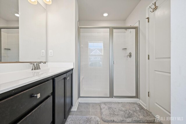 bathroom with an enclosed shower, tile patterned flooring, and vanity