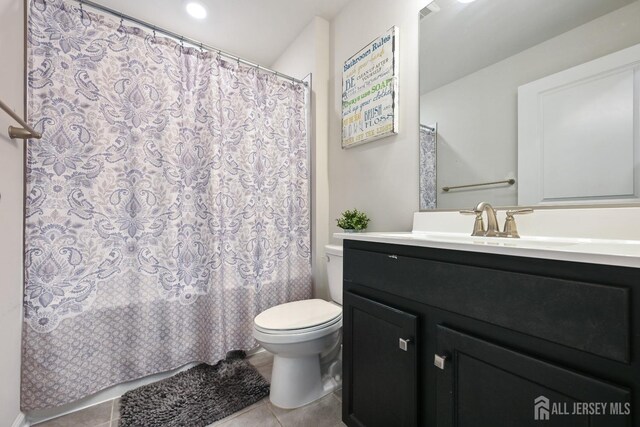 bathroom with toilet, tile patterned flooring, and vanity