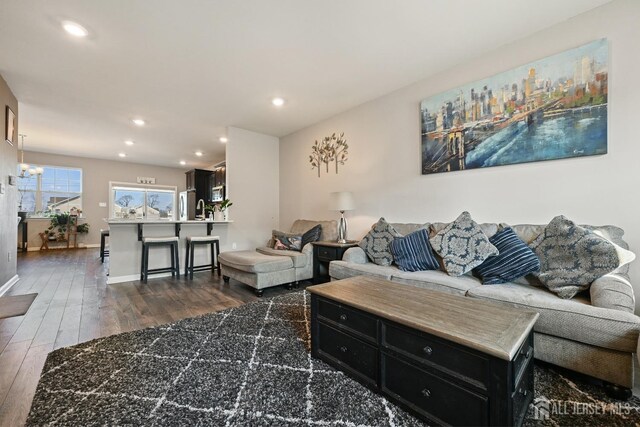 living room with a notable chandelier and dark hardwood / wood-style flooring