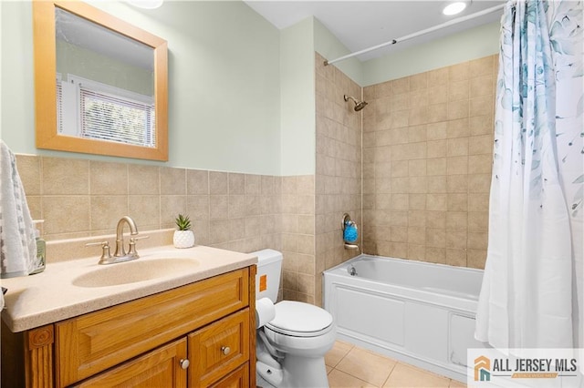 full bathroom featuring shower / tub combo with curtain, tile patterned floors, toilet, tile walls, and vanity