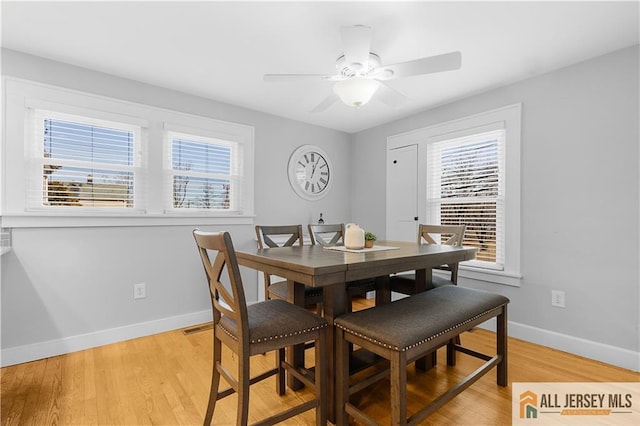 dining area with a wealth of natural light, ceiling fan, and light wood-type flooring