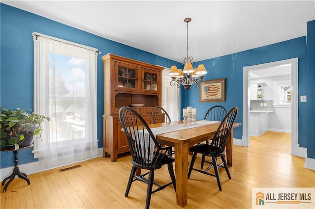 dining room with a chandelier and light wood-type flooring