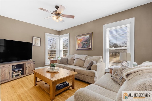 living room with light hardwood / wood-style flooring and ceiling fan