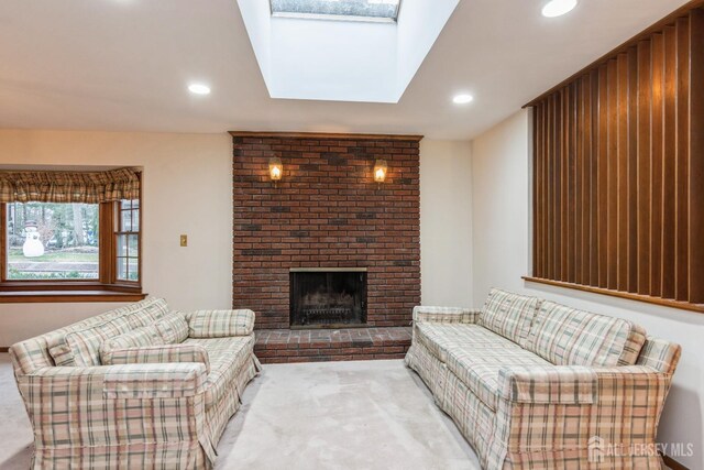 carpeted living room with a skylight and a fireplace