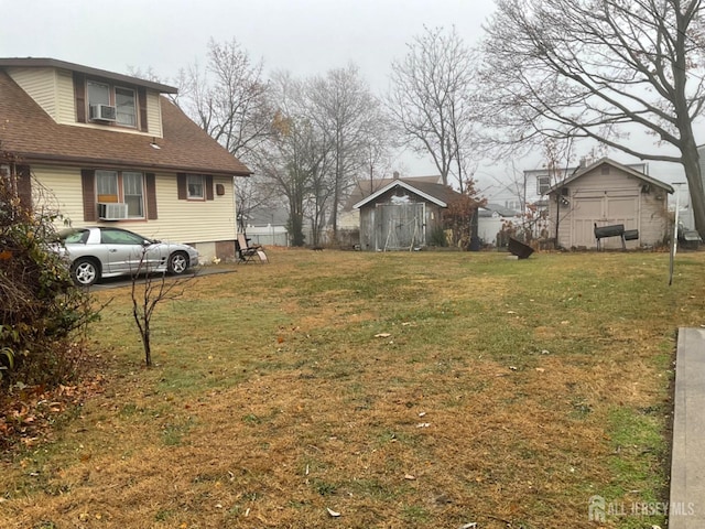 view of yard with an outbuilding, a storage unit, and cooling unit