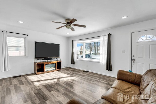 living room featuring hardwood / wood-style flooring, plenty of natural light, and ceiling fan