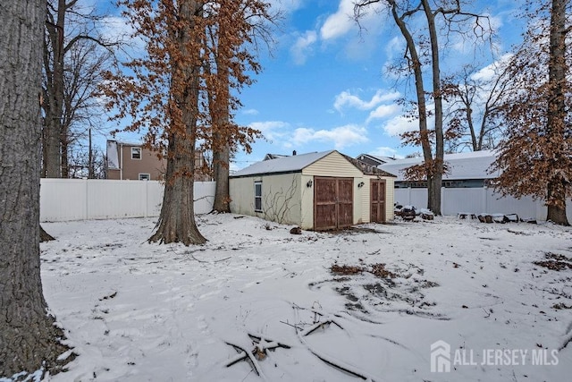 yard covered in snow with a shed