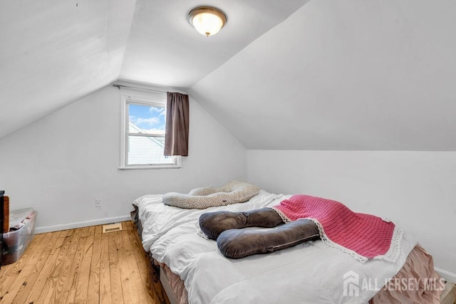 bedroom with lofted ceiling and hardwood / wood-style floors