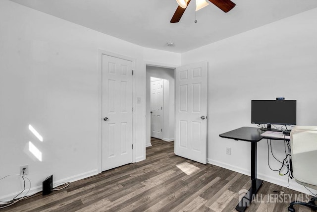 unfurnished office featuring a ceiling fan, baseboards, and wood finished floors