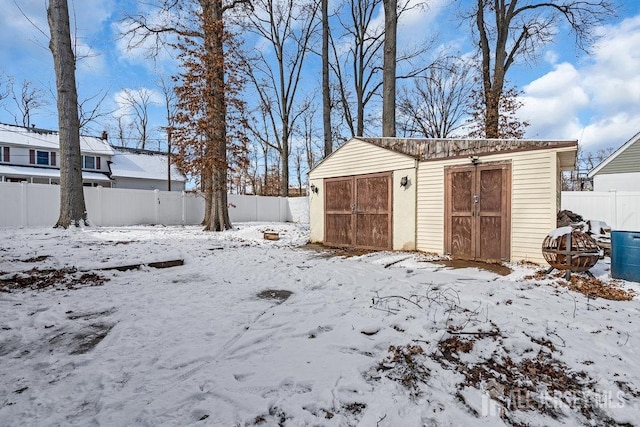 exterior space with a shed, a detached garage, and fence