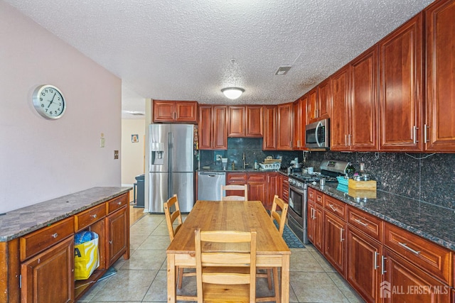 199 Prestwick Way, Edison, NJ 08820 - kitchen with appliances with stainless steel finishes, decorative backsplash, light tile patterned flooring, dark stone counters, and a textured ceiling