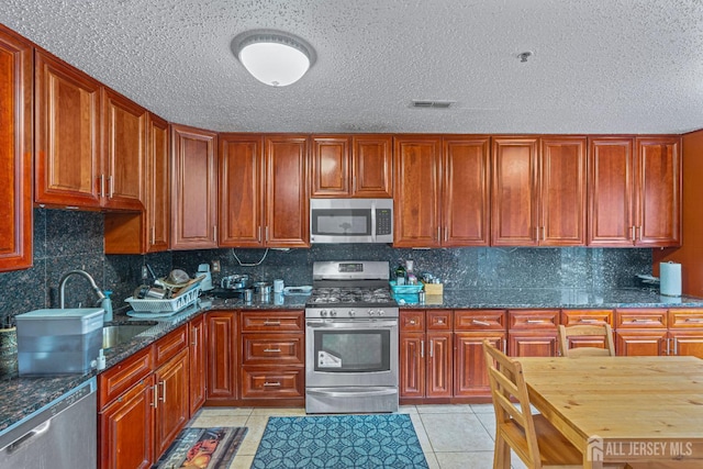 199 Prestwick Way, Edison, NJ 08820 - kitchen featuring stainless steel appliances, light tile patterned floors, backsplash, dark stone counters, and a textured ceiling