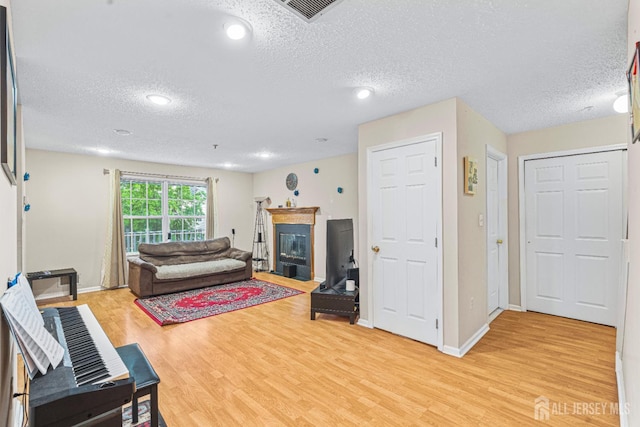 199 Prestwick Way, Edison, NJ 08820 - living room with a textured ceiling, a glass covered fireplace, light wood finished floors, and recessed lighting