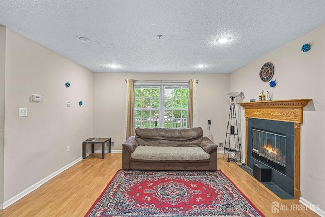 199 Prestwick Way, Edison, NJ 08820 - living area featuring light wood finished floors, a textured ceiling, a glass covered fireplace, and recessed lighting