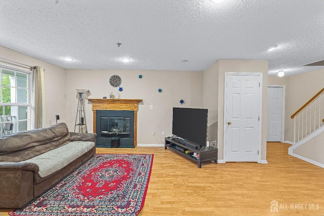 199 Prestwick Way, Edison, NJ 08820 - living area with a textured ceiling, light wood-style floors, stairway, a glass covered fireplace, and recessed lighting