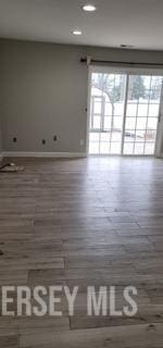 empty room featuring recessed lighting, baseboards, and wood finished floors