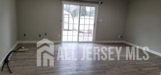 unfurnished room featuring baseboards and wood finished floors