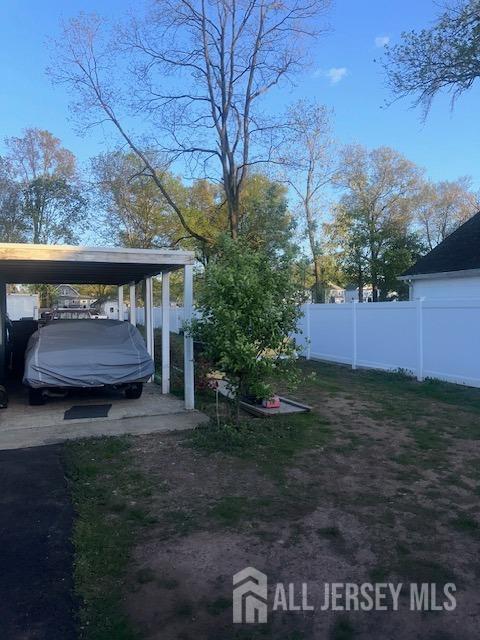 view of yard featuring fence and a carport