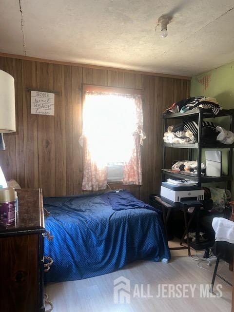 bedroom featuring wood walls and wood finished floors