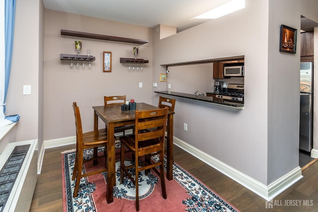 dining area featuring dark wood-type flooring